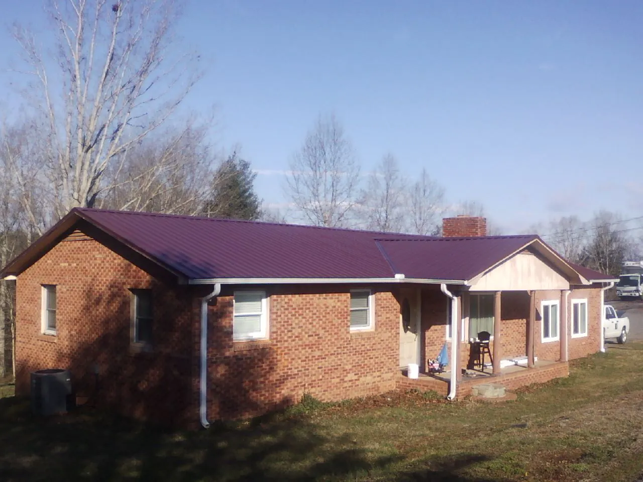 Burgundy metal roof on a brick ranch home with a new addition in Vermontville