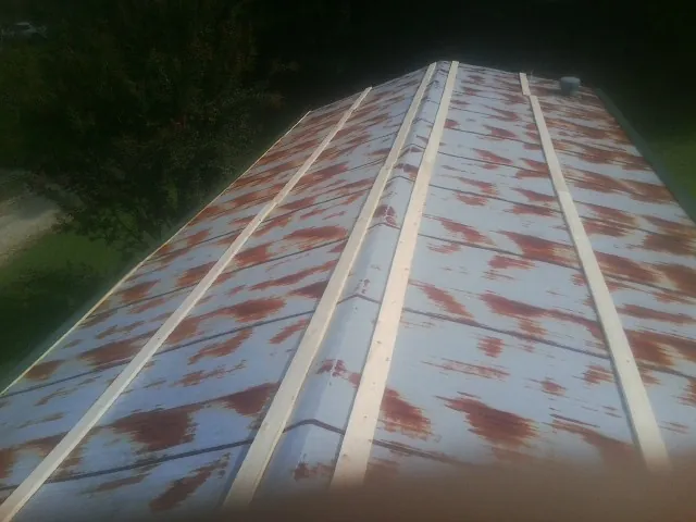 Rusted metal roof panels with new wood purlins before replacement — Storm Damage Roof Repair in Vermontville by Roofing Brothers