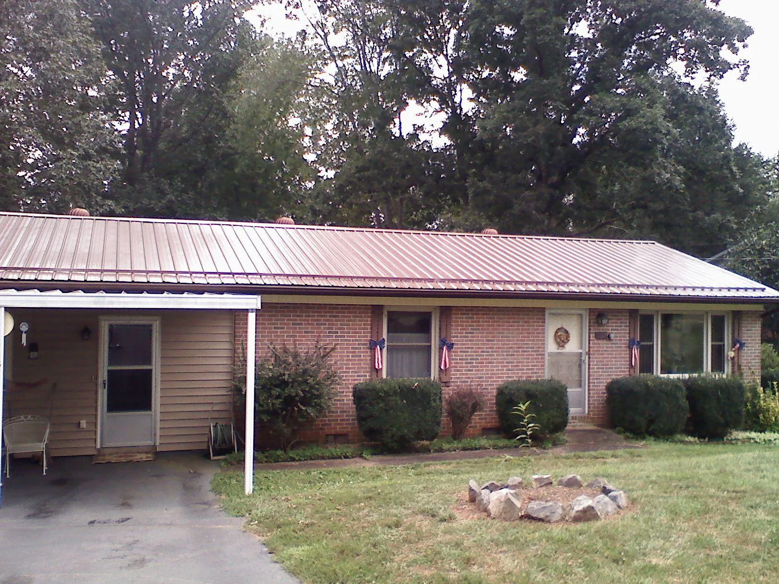 Bronze metal roof and carport on a brick ranch home — Roof Repair work by our crew in Vermontville
